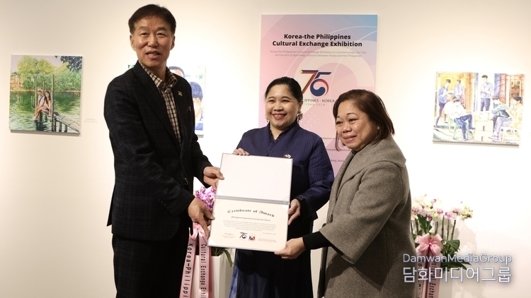 Chairman Lee Jon-young of Damwha Media Group (left) delivers a certificate of award to Maria Apo, director of the Philippine Department of Tourism (right).