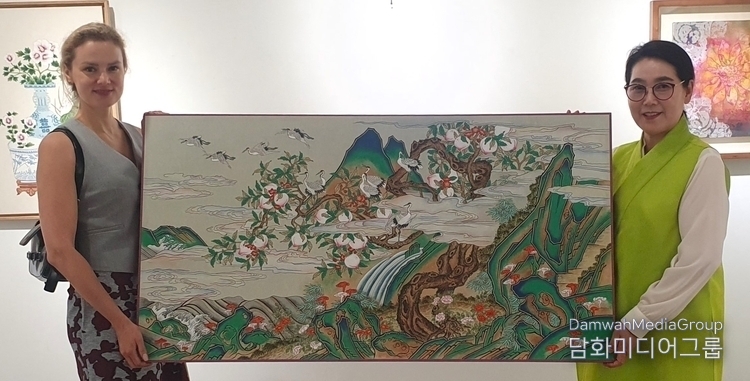 Prof. Lee Mi-hyung of Myongji University (right) donates her artwork to Mrs. Maryna Kazhurava, the spouse of Ambassador Chernetsky of Belarus.