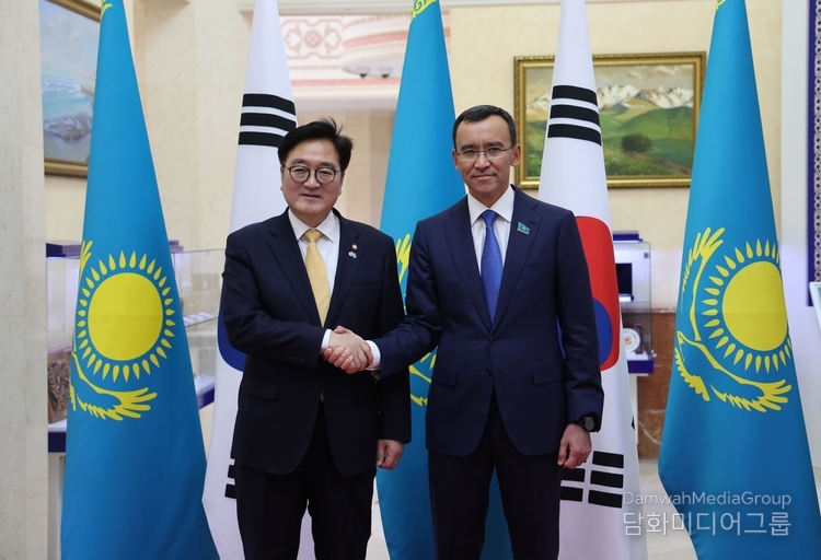 Senate Chairman Maulen Ashimbayev and Speaker Woo Won-shik shake hands.