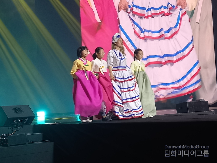 Natalia Federighi de Cuello, the spouse of the Ambassador of the Dominican Republic, who was dressed in traditional clothes from her country, walks along with Korean girls.