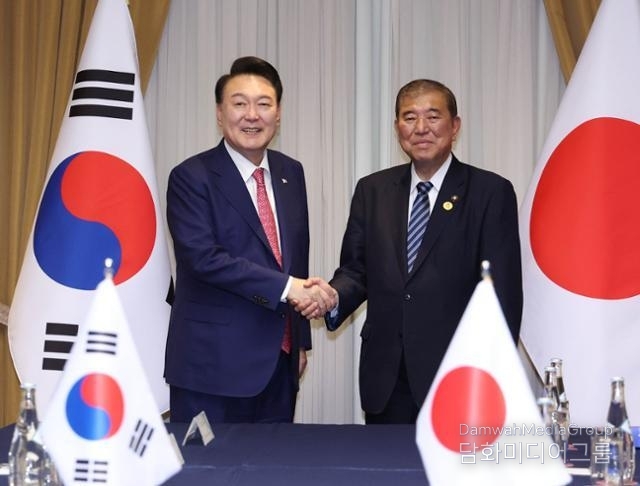 President Yoon Suk-yeol (left) shakes hands with Japanese Prime Minister Shigeru Ishiba at a hotel in Lima, Peru, on Nov. 16, 2024.