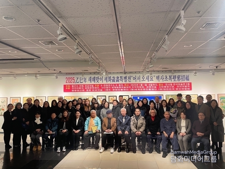 Lee Jon-young, publisher of Monthly K Folk Paintings, takes a commemorative photo with participants in the New Year (Byeoksachobok) Sehwa Exhibition on Jan. 1, 2025.
