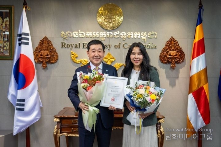Lee Jae-young (left), governor of Jeungpyeong-gun in Chungcheongbuk-do, receives a plaque of appreciation from Cambodian Ambassador to Korea Chring Botumrangsay at the Cambodian Embassy in Seoul on Jan. 8.