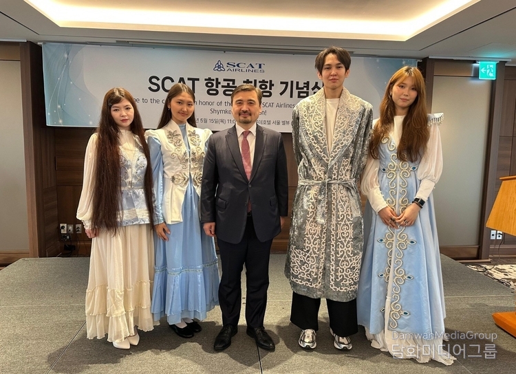 Ambassador of Kazakhstan Nurgali Arystanov poses with students in traditional Kazakh attire.