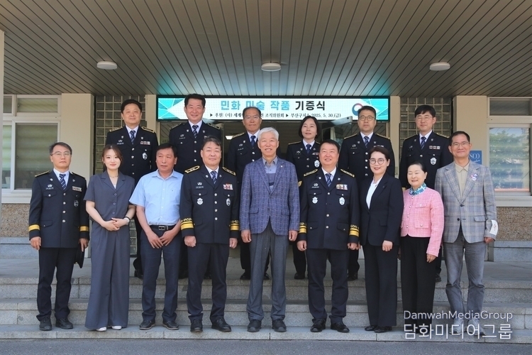 Chairman Lee Jon-young of World Peace Art Exhibition Organizing Committee (center, front row) and Kim Dong-hyun, Commissioner of the Daegu Regional Correctional Office, take a commemorative photo with other guests after the donation of the artwork. / Courtesy of Daegu Regional Correctional Office