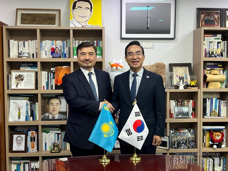 Ambassador of Kazakhstan Nurgali Arystanov (left) and Chairman of the Korea–Kazakhstan Inter-Parliamentary Friendship Group Park Hong-keun shake hands and pose for a photo.