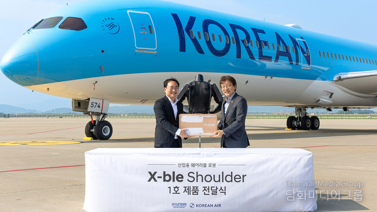 A Hyundai Motor official delivers the company’s 1st ‘X-ble Shoulder’ wearable robot to a Korean Air official.