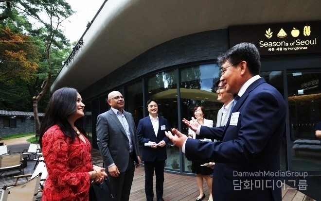 Oh Seung-rok, mayor of Nowon-gu District, Seoul (right), converses with foreign ambassadors to South Korea in front of the treehouse at Surakhyu Natural Recreation Forest on July 15. / Courtesy of Nowon-gu District