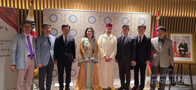 Ambassador Chafik Rachadi and Mrs. Leila Chelly Rachadi take a commemorative photo with Korean businessmen, greeting them at the entrance of the reception hall.