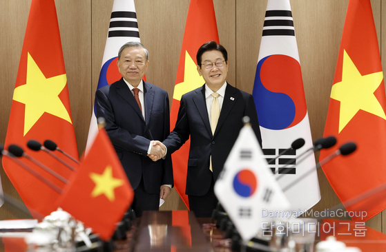 President Lee Jae-myung (right) and To Lam, general secretary of the Communist Party of Vietnam, shake hands before they hold summit at the presidential office in Seoul, on Aug. 11, 2025.