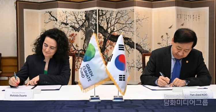 Deputy Prime Minister Koo Yun-cheol (right) signs a memorandum of understanding for the establishment of a Junior Professional Officer (JPO) position at the Green Climate Fund (GCF) after meeting with GCF executive director Mafalda Duarte at the Government Complex Seoul in Jongno-gu, Seoul on Oct. 24. / Courtesy of the Ministry of Strategy and Finance