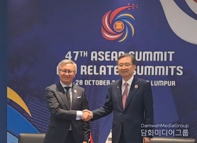 Minister of Foreign Affairs Cho Hyun (right) shakes hands with Lao Foreign Minister Thongsavanh Phomvihane on October 27.
